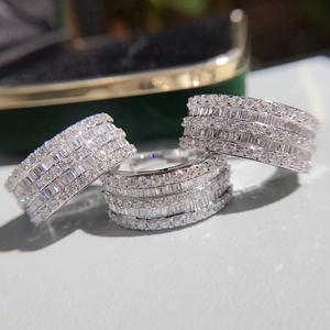 Close-up of three wide silver bands with multi-row square and round cubic zirconia inlays