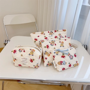 Detailed set of four quilted cotton pouches featuring colorful floral and character patterns