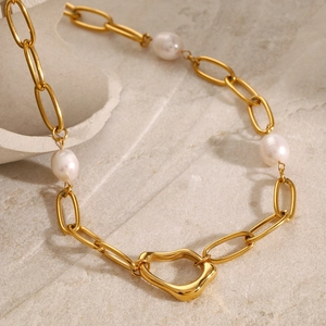 Detail of 18k gold link chain necklace with pearls and irregular heart-shaped clasp