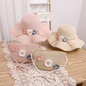 Détail du chapeau de paille et du sac fleuri avec des décorations florales artisanales