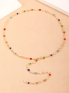 Detalle de collar tipo Y chapado en oro con gemas coloridas y colgante de borla larga