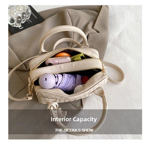 Detail view of the spacious inner compartment of the beige woven Boston bag with dual zippers