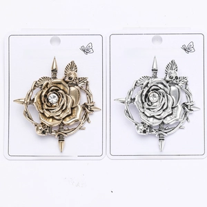 Detailed view of vintage alloy skull and rose brooches in bronze and silver finish