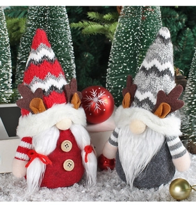 Détail de gnomes de Noël rouges et gris avec bois de renne dans un décor de neige