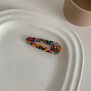 Close-up of colorful marble pattern acetate hair clip with metal duckbill clip design