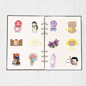 Detailed view of assorted cute cartoon bear and flower stickers on a white notebook page