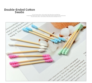Close-up of dual-tip colorful cotton swabs with spiral and round heads on magazine background