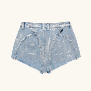 Dettaglio degli shorts in denim azzurro con finitura argento e cuciture curve