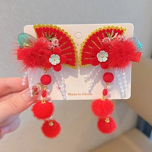 Detail of red Chinese fan hair clips with soft fur balls and beaded tassels for girls