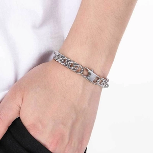 Close-up of polished silver stainless steel Cuban link chain bracelet worn on wrist