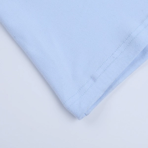 Gros plan du tissu bleu clair d'une robe en dentelle montrant les coutures et la texture