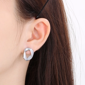 Close-up of minimalist silver irregular geometric hollow earrings on female model ear
