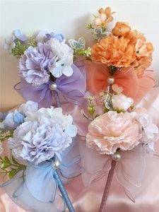 Detail of colorful silk carnation corsages with pearls and mesh butterfly ribbons