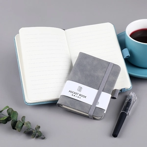 Minimalist grey suede notebook with elastic band and lined pages on office desk