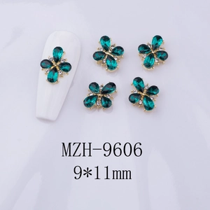 Macro shot of 9x11mm green flower nail art charms with golden base and tiny white crystals