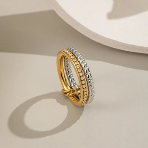 Détail d'une bague multicouche en or et argent ornée de pierres de zircon blanc étincelantes