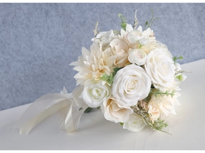 Detail of bridal bouquet with white roses, dahlias and eucalyptus leaves with silk ribbon