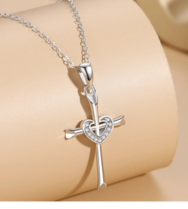 Macro shot of 925 silver cross pendant with heart diamond inlay and fine chain detail