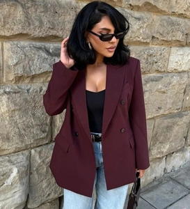 Scatto all'aperto di un blazer doppiopetto bordeaux con tasche a patta su una modella