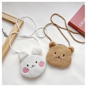 Detail of plush animal crossbody bags with cute embroidered faces in white and brown