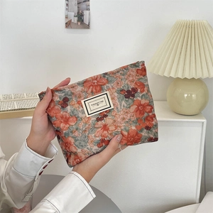 Detail of floral corduroy makeup bag in warm orange tones with Pleasant Time label