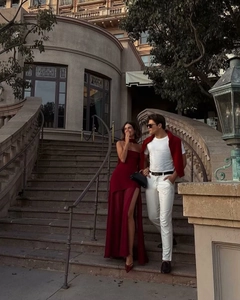 Elegant burgundy high slit evening gown and white menswear on classic outdoor stairs