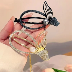 Detail of fishtail hair clips with sparkling rhinestones, pearls, and elegant long tassels