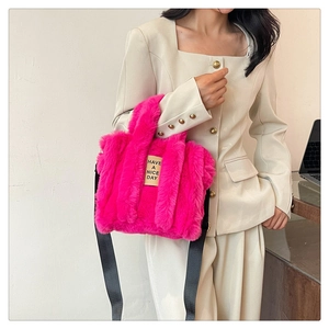 Detail of rose pink plush tote bag with 'HAVE A NICE DAY' label and black strap