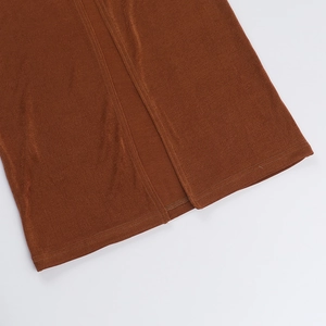 Detailed close-up of the side slit and textured knit fabric on this brown summer dress