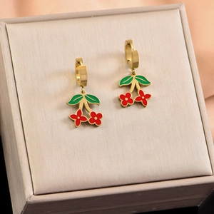 Macro detail of gold cherry earrings with red flower petals and green enamel leaves