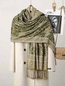 Detail of green paisley floral scarf with elegant tassels draped on a white coat