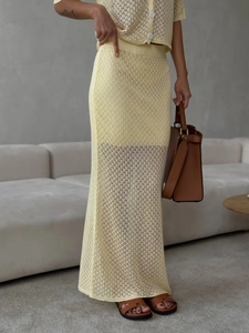 Detailed knit pattern on light yellow two-piece crochet cardigan and midi skirt set