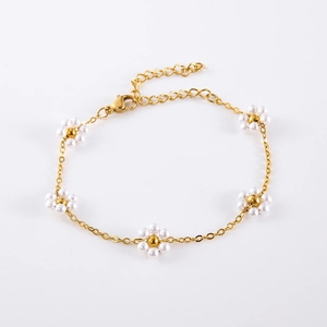 Detail of bohemian daisy bracelet with white pearls and gold chain link for women