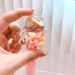 Rainbow liquid bear keychain with colorful glitter and golden bell in clear acrylic bottle