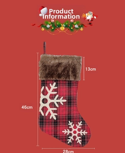 Détail d'une chaussette de Noël à carreaux rouges et noirs avec flocons et fausse fourrure
