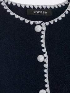 Detailed view of navy knit cardigan with contrast crochet trim and matching buttons