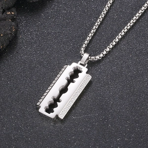 Macro shot of silver CNC diamond-set razor blade pendant with steel pearl chain