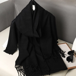 Close-up of soft black cashmere-like scarf showing thick texture and fringe details