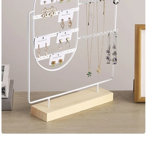 Detail of white metal jewelry stand with wooden base for earrings and necklaces
