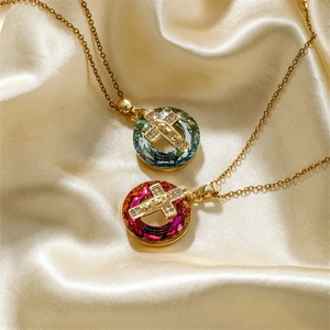 Religious necklace with gold chain and Maria cross pendant on champagne satin fabric