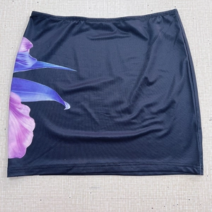 Détail de la mini-jupe noire moulante avec un imprimé floral violet sur le côté