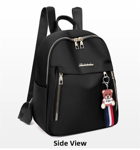 Detail showing high-quality black nylon backpack material with metal zippers and cute bear charm