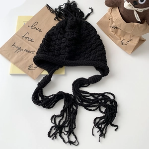Fashionable black chunky knit beanie with long tassels and ear protection