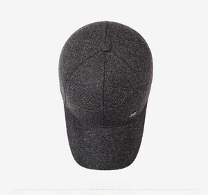 Vista dall'alto della texture in tweed grigio e logo in metallo del cappello invernale
