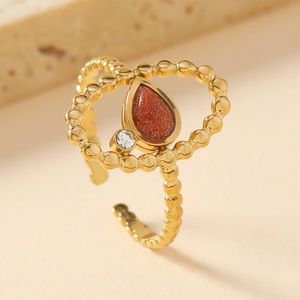 Detailed macro view of gold-plated teardrop gemstone ring with bead texture band