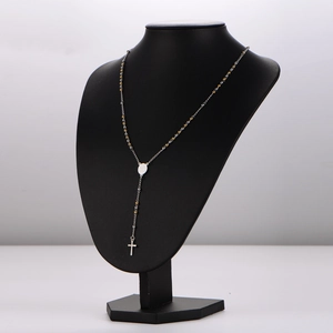 Rosary necklace with silver chain, gold beads, oval medallion and cross on black bust