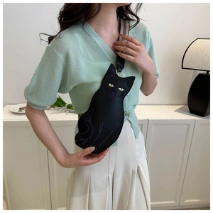 Crossbody bag with a cute black cat design and striped shoulder strap on a model