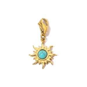 Detail of a golden sun pendant with turquoise stone and a stainless steel lobster clasp