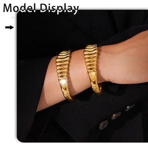 Detail of fashion gold plated herringbone textured cuffs on model in black suit