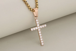 Macro shot of gold cross necklace featuring elegant clear stones inlay and fine chain